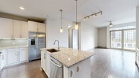 Located in the heart of Midtown Atlanta at 782 Peachtree St NE, this single-floor residence offers a thoughtfully designed layout with contemporary finishes and quality craftsmanship throughout. The open-concept kitchen serves as the focal point of the living area, showcasing a large center island topped with granite countertops, an undermount sink, and elegant pendant lighting. White shaker-style cabinetry lines the walls, complemented by a subway tile backsplash, stainless steel appliances including a French door refrigerator, gas range, built-in microwave, and dishwasher. Rich hardwood flooring extends through the main living areas, adding warmth and continuity. A dedicated in-unit laundry closet with a stacked washer and dryer provides added convenience. The bedrooms feature plush carpeting and neutral walls, creating a calm and restful atmosphere, with access to well-organized closets. The primary bathroom is generously sized, offering a dual-sink vanity with granite countertops, large-format tile flooring, a soaking tub, and a separate glass-enclosed shower. An additional bathroom mirrors the same refined aesthetic. The clean, modern palette of whites and warm neutrals creates a bright, cohesive ambiance throughout this well-appointed Midtown Atlanta residence.