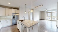 Located in the heart of Midtown Atlanta at 782 Peachtree St NE, this single-floor residence offers a thoughtfully designed layout with contemporary finishes and quality craftsmanship throughout. The open-concept kitchen serves as the focal point of the living area, showcasing a large center island topped with granite countertops, an undermount sink, and elegant pendant lighting. White shaker-style cabinetry lines the walls, complemented by a subway tile backsplash, stainless steel appliances including a French door refrigerator, gas range, built-in microwave, and dishwasher. Rich hardwood flooring extends through the main living areas, adding warmth and continuity. A dedicated in-unit laundry closet with a stacked washer and dryer provides added convenience. The bedrooms feature plush carpeting and neutral walls, creating a calm and restful atmosphere, with access to well-organized closets. The primary bathroom is generously sized, offering a dual-sink vanity with granite countertops, large-format tile flooring, a soaking tub, and a separate glass-enclosed shower. An additional bathroom mirrors the same refined aesthetic. The clean, modern palette of whites and warm neutrals creates a bright, cohesive ambiance throughout this well-appointed Midtown Atlanta residence.