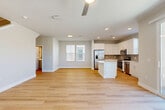 Located at 7951 W Whitney Dr in Peoria, AZ, this well-appointed two-story home offers 3 bedrooms and 2 bathrooms thoughtfully distributed across two equally sized floors. The main level features an open-concept kitchen and living area bathed in natural light, with light wood-tone flooring flowing throughout. The kitchen is a standout, equipped with white shaker cabinetry, a neutral tile backsplash, a white quartz island, and a full suite of stainless steel appliances including a French door refrigerator, range, microwave, and dishwasher. A ceiling fan completes the comfortable living area. The lower level also includes a staircase, a garage with an automatic opener, and a dedicated laundry room with side-by-side washer and dryer units beneath white upper cabinetry. Sliding glass doors lead to a private, walled backyard featuring a paver patio, turf, and desert landscaping. Upstairs, three bedrooms offer light wood flooring, ceiling fans, and ample natural light through blinds-fitted windows. The spacious primary bedroom includes sliding glass doors to an outdoor view. Two bathrooms serve the home, including a clean, modern bath with a glass-enclosed tiled shower. The hallway and closets complete this efficient, move-in-ready layout.