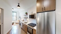 Located in the Uptown neighborhood of Chicago, this thoughtfully designed single-floor residence at 1133 W Lawrence Ave combines modern aesthetics with functional living. Polished concrete floors flow seamlessly throughout, reflecting natural light and lending an industrial-chic character to the space.

The galley-style kitchen is a standout feature, equipped with stainless steel appliances including a gas range, oven, built-in microwave, and full-size refrigerator. Warm wood cabinetry is paired with crisp white upper cabinets and subway tile backsplash, complemented by open metal shelving and a deep undermount sink with a brushed gold faucet. Pendant lighting adds a refined touch overhead.

The living area sits adjacent to the kitchen, bathed in natural light from large black-framed windows that frame views of the surrounding Chicago streetscape. The bedroom is a calm, private retreat featuring a generous window with city views, a wall-mounted split AC unit, and warm wood flooring. The bathroom showcases clean, minimalist design with floor-to-ceiling white tile, a glass-enclosed walk-in shower, and matte black fixtures throughout. The unit's entry area is clean and functional, with ample clearance and a modern door system. The overall ambiance is bright, contemporary, and well-appointed.