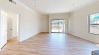 Located at 550 N Figueroa in downtown Los Angeles, this 2-bedroom, 2-bathroom residence offers a well-designed single-floor layout. The open living room is highlighted by light hardwood flooring, crown molding, and a sliding glass door that leads to a spacious private terrace. The terrace features a classic balustrade railing and sweeping views of swaying palm trees and the surrounding cityscape, providing a true Southern California ambiance.

The kitchen is thoughtfully designed with a galley-style layout, featuring rich granite countertops, light maple cabinetry, a breakfast bar peninsula, and a full suite of stainless steel appliances including a gas range, microwave, refrigerator, and dishwasher. Recessed lighting and a window overlooking the terrace add brightness to the space.

Both bedrooms are generously sized, with the same warm hardwood flooring carried throughout and windows that invite natural light and outdoor views. The primary bedroom connects to a walk-in closet equipped with built-in shelving and hanging rods for ample storage. The bathrooms are finished with tile flooring, warm wood vanities, and dark marble-style granite countertops, with one bathroom featuring a glass-enclosed shower.