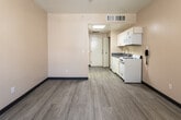 Located at 1091 Everton Pl in Riverside, CA, this single-floor unit offers a practical and straightforward layout designed for comfortable everyday living. The open-concept main living area is finished with durable wood-look flooring that runs throughout, providing a clean and cohesive aesthetic. Warm neutral tones on the walls, complemented by a contrasting dark accent wainscoting in the main room, create a distinct visual character. Natural light filters in through a window fitted with vertical blinds, brightening the space and adding an airy feel.

The kitchen is efficiently arranged along one wall and comes equipped with white cabinetry, a gas range, an over-the-range microwave, and a single-basin sink with a modern faucet set into a gray countertop. A skylight overhead floods this area with additional natural light, making the kitchen feel open and well-lit. Storage is provided through both upper and lower cabinetry.

The bathroom features a single-sink vanity with a gray countertop and white cabinetry, a large mirror, and a full tub-shower combination. The flooring continues seamlessly from the rest of the unit, maintaining a uniform look. Overall, this space offers a functional, no-frills layout with consistent finishes throughout, well-suited for those seeking a practical living environment in Riverside.
