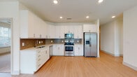 Located at 1000 Artistry Dr in Midlothian, VA, this single-floor residence offers a thoughtfully designed, open-concept layout with modern finishes throughout. The kitchen is a standout feature, equipped with crisp white shaker cabinetry, stainless steel appliances including a range, over-the-range microwave, dishwasher, and side-by-side refrigerator with an ice and water dispenser. A textured tile backsplash adds visual interest, while light wood-tone flooring ties the kitchen seamlessly into the open living area. The living space is generously proportioned, bathed in natural light from multiple windows, and anchored by a ceiling fan overhead. Bedrooms are carpeted for comfort, each featuring ceiling fans and windows with blinds that allow for ample natural light. The primary bathroom is well-appointed with a dual-sink vanity, large mirror, walk-in shower with grab bars, and tile flooring. A second bathroom offers a white vanity with a soaking tub and shower combination. Additional highlights include a spacious walk-in closet outfitted with wire shelving and basket storage. The home's clean, neutral palette and consistent modern finishes create a bright, cohesive living environment throughout.