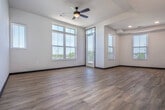 This well-appointed 2-bedroom, 2-bathroom residence offers a thoughtfully designed open-concept layout spread across a generous single floor. The kitchen serves as a central highlight, featuring dark espresso cabinetry, a white quartz waterfall island with an undermount sink, subway tile backsplash, stainless steel appliances, and stylish pendant lighting overhead. Light hardwood-style flooring flows throughout the main living areas, complementing the bright, neutral palette and contemporary finishes.

The spacious living room is bathed in natural light from large multi-pane windows and includes a ceiling fan and direct access to a private balcony, which offers open outdoor views of the surrounding landscape. Both bedrooms are carpeted for comfort, with large windows that fill each room with natural light. The generously sized primary bedroom features its own ceiling fan and an en-suite bathroom complete with a quartz vanity, dark wood cabinetry, a large framed mirror, and a glass-enclosed shower. A dedicated walk-in closet adjoins the primary bath. The second bathroom mirrors the same upscale finishes and includes a bathtub. A convenient in-unit laundry closet with a front-load washer completes this well-equipped residence.