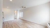 This 1-bedroom, 1-bathroom unit in Oak Park, Michigan offers a clean, modern design with a thoughtful single-floor layout. Light-toned hardwood-style flooring runs throughout the entire space, creating a cohesive and airy feel. The open-concept living room is bright and welcoming, featuring a ceiling fan with a built-in light fixture, neutral white walls, and vertical blind-covered windows that allow for natural light control. The kitchen seamlessly adjoins the living area and is outfitted with crisp white shaker-style cabinetry extending to the ceiling, granite-look countertops, a single-basin sink, and a full suite of stainless steel appliances including a refrigerator, electric range, and over-the-range microwave. The bedroom is a comfortable, well-sized retreat with its own ceiling fan, a large window with vertical blinds offering natural light and outdoor views, and a wall-unit HVAC system for individualized climate control. The entry door features decorative glass panels, adding a welcoming touch to the front entry. The overall ambiance is bright, clean, and move-in ready, with a consistent neutral palette that provides a versatile backdrop for any décor style.