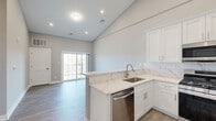 Located at 2421 Bristol Road in Warrington, PA, this thoughtfully designed one-bedroom, one-bathroom residence offers a bright and modern living experience across a well-utilized single floor. The open-concept layout is anchored by a striking kitchen featuring white shaker cabinetry, marble-look quartz countertops, a tile backsplash, stainless steel appliances including a gas range, built-in microwave, dishwasher, and refrigerator, and a peninsula that separates the kitchen from the living area. Soaring vaulted ceilings in the main living space create an impressive sense of openness, while recessed lighting and wood-look plank flooring throughout lend a clean, contemporary aesthetic. Sliding glass doors in the living area allow for natural light and outdoor access. The spacious primary bedroom is fitted with large multi-pane windows that frame pleasant outdoor views of the surrounding neighborhood, and benefits from direct access to a dedicated closet. The full bathroom is elegantly appointed with marble-look tile on the floors and tub surround, a white vanity with quartz countertop, and a tub-shower combination. A hallway and additional closet provide practical storage solutions, completing this well-appointed and move-in-ready residence.