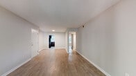 This single-floor residence offers a thoughtfully laid-out living space with a clean, neutral aesthetic throughout. The open living and dining areas are finished with warm wood-look laminate flooring and light gray walls, creating a bright and welcoming atmosphere. A sliding glass door in the living area allows natural light to fill the space and provides outdoor access. A dedicated dining area features a classic pendant light fixture and a window with views of mature trees, adding a touch of greenery to mealtimes.

The kitchen is well-equipped with rich dark espresso cabinetry, light stone-look countertops, a tiled backsplash, and stainless steel fixtures including a double sink. Ample upper and lower cabinet storage is complemented by a full suite of appliances.

The bedrooms are carpeted for comfort and each features a ceiling fan with light fixture, generous natural light from windows with blinds, and closet space. The primary bedroom includes two closets, providing excellent storage. The full bathroom is finished with a dark vanity, marble-look countertop, a large mirror, and a tub-shower combination with clean white tile surround. Overall, the space presents a functional and comfortable layout with consistent finishes throughout.