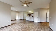Located in Everett, WA, this two-bedroom, two-bathroom unit offers a thoughtfully designed single-floor layout with a comfortable and functional living experience. The open-concept living, dining, and kitchen area serves as the heart of the home, featuring wood-look plank flooring, a ceiling fan, and a striking black-surround fireplace flanked by windows that invite natural light and outdoor views. The kitchen is outfitted with dark espresso cabinetry, white countertops, stainless steel appliances including a range and over-the-range microwave, and an adjacent pantry for added storage convenience. A dedicated in-unit laundry room provides washer and dryer hookups with overhead shelving. Both bedrooms are carpeted and bright, each with windows offering views of the surrounding greenery and neighborhood. The primary bedroom is a comfortable size with ample closet space, while a hallway connects the bedrooms to the two full bathrooms, one of which features a soaking tub with grab bars. With five closets throughout, storage is plentiful. The neutral color palette and clean finishes create a calm, move-in-ready atmosphere throughout the entire unit.