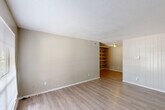 Located at 710 S College Rd in Lafayette, Louisiana, this single-floor residence offers 2 bedrooms and 3 bathrooms within a thoughtfully laid-out floor plan. The living room greets you with light-toned wood-look flooring, neutral walls, a textured ceiling, and a large window that invites natural light and outdoor views. A distinctive built-in shelving unit connects the living area to the rest of the home, adding both character and functional storage. The galley-style kitchen features white cabinetry, granite-look countertops, and an electric range, with a pass-through view to the built-in shelving beyond. The bedrooms are carpeted for comfort; the primary bedroom is generously sized and includes a ceiling fan with light fixture, a window with natural light, and a sliding-door closet with a full-length hanging rod. The bathrooms are consistently finished with white vanity cabinetry, granite-look countertops, large mirrors with overhead lighting, and white medicine cabinets. A connecting hallway ties all rooms together efficiently. The overall aesthetic is clean, neutral, and functional, making the space highly adaptable for a variety of living arrangements.