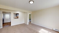 This single-floor, 2-bedroom, 1-bathroom residence at 120 Niagara Street in Middletown, Rhode Island offers a straightforward and functional layout. The living area is finished with wall-to-wall neutral carpeting, warm beige walls, and a pass-through opening that connects directly to the kitchen, enhancing the sense of openness between the two spaces. Flush-mount ceiling lighting provides consistent illumination throughout.

The kitchen is well-appointed with dark espresso shaker-style cabinetry, light stone-look countertops, and a full suite of stainless steel appliances including a gas range, over-the-range microwave, and dishwasher. A stainless steel double sink completes the practical workspace.

Both bedrooms are carpeted and feature baseboard heating, neutral walls, and windows dressed with vertical blinds that allow natural light to filter in. Each room offers a comfortable and quiet atmosphere suitable for rest or use as a home office.

The bathroom includes a full tub-shower combination with a clean white surround, a white vanity, and wood-look vinyl flooring, providing a clean and functional space. Baseboard heating is present throughout, ensuring consistent warmth across the unit.