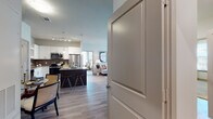 This thoughtfully designed single-floor residence offers a seamless blend of modern style and functional living. The open-concept kitchen is a standout feature, showcasing white cabinetry, granite countertops, a large island with bar seating, subway tile backsplash, stainless steel appliances, and pendant lighting — all flowing naturally into the dining and living areas. Light wood-tone flooring runs throughout the main living spaces, enhancing the bright, airy atmosphere.

The living room is generously proportioned, bathed in natural light from large windows, and opens toward multiple bedrooms. The primary bedroom features plush carpeting, dual windows with views to the exterior, a ceiling fan, and ample room for a full suite of furniture. A second bedroom mirrors the cozy aesthetic with soft carpeting and warm lighting. A flexible den or office space offers wood-look flooring, abundant natural light from multiple windows, and room for a dedicated workspace alongside lounge seating.

The bathrooms are finished with granite vanity countertops, white cabinetry, wood-look tile flooring, and tub-shower combinations framed by elegant large-format tile surround. Every room in this residence reflects a cohesive, contemporary design sensibility with an emphasis on comfort and practicality.