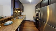 Located at 3535 Bryant Ave S in the Uptown neighborhood of Minneapolis, MN, this single-floor residence offers a practical and comfortable layout with thoughtfully designed living spaces throughout.

The galley-style kitchen is a standout feature, boasting dark espresso cabinetry, granite-look countertops, a mosaic tile backsplash, hardwood flooring, and a full suite of stainless steel appliances including a gas range, over-the-range microwave, and refrigerator. A pass-through window connects the kitchen to the adjacent dining area, which features hardwood flooring, a pendant light fixture, and a window with vertical blinds that brings in natural light.

The living room is generously sized with plush carpeting, a textured ceiling, and a large sliding glass door that fills the space with natural light and provides outdoor access. Dark wood baseboards add a contrasting design accent throughout the unit.

The bedroom offers comfortable carpeted flooring, a ceiling fan with light fixture, a window with vertical blinds, and baseboard heating. A closet with a full-panel door provides ample storage.

The bathroom features a single-sink vanity with a light countertop, a tiled drop-in sink, a tub-shower combination with a decorative curtain, and a drop-panel ceiling. The warm wall tones give the bathroom a cozy, inviting feel.