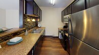 Located at 3535 Bryant Ave S in the Uptown neighborhood of Minneapolis, MN, this single-floor residence offers a practical and comfortable layout with thoughtfully designed living spaces throughout.

The galley-style kitchen is a standout feature, boasting dark espresso cabinetry, granite-look countertops, a mosaic tile backsplash, hardwood flooring, and a full suite of stainless steel appliances including a gas range, over-the-range microwave, and refrigerator. A pass-through window connects the kitchen to the adjacent dining area, which features hardwood flooring, a pendant light fixture, and a window with vertical blinds that brings in natural light.

The living room is generously sized with plush carpeting, a textured ceiling, and a large sliding glass door that fills the space with natural light and provides outdoor access. Dark wood baseboards add a contrasting design accent throughout the unit.

The bedroom offers comfortable carpeted flooring, a ceiling fan with light fixture, a window with vertical blinds, and baseboard heating. A closet with a full-panel door provides ample storage.

The bathroom features a single-sink vanity with a light countertop, a tiled drop-in sink, a tub-shower combination with a decorative curtain, and a drop-panel ceiling. The warm wall tones give the bathroom a cozy, inviting feel.
