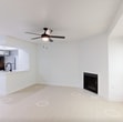 Located at 1100 Falls Creek Lane in Charlotte, NC, this 540-square-foot, one-bedroom, one-bathroom apartment is thoughtfully laid out across a single floor. The open living room serves as the heart of the unit, featuring light wood-style flooring, crisp white walls, a ceiling fan with light fixture, and a corner fireplace that adds warmth and character. A large window fitted with blinds fills the space with natural light and provides views of surrounding greenery. The pass-through kitchen connects seamlessly to the living area and includes white cabinetry, stainless steel appliances, and a countertop bar. The 130-square-foot bedroom is carpeted for comfort, equipped with its own ceiling fan, a natural light window, and direct access to a dedicated closet. A hallway connects the main living areas to the full bathroom, which features light wood-style tile flooring, a soaking tub, and a full-height marble-patterned tile surround, lending a clean and elegant aesthetic. The unit's neutral color palette and consistent design choices create a cohesive, modern ambiance throughout.