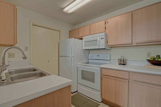 Vista de la cocina con refrigerador, horno y microondas de St. James Place - St. James Place