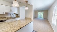 This renovated 2-bedroom apartment at Heritage Cove in Temple Terrace, FL, spans 520 square feet across a single floor, offering an efficient and comfortable layout. The living area features neutral-toned carpet, a ceiling fan with light fixture, and clean white walls that create a bright, open atmosphere. A pass-through opening connects the living space to the kitchen, which is equipped with white cabinetry, countertops, and standard appliances, including a dishwasher. Durable hardwood-style flooring in the kitchen and entryway contrasts neatly with the soft carpeting throughout the rest of the unit. The spacious primary bedroom measures 390 square feet and includes a ceiling fan, plush carpet, a sliding door closet with built-in shelving, and a window with outdoor views of lush greenery, allowing for abundant natural light. The second bedroom also features carpet flooring and a window overlooking the outdoors. The unit includes access to a private balcony through vertical blinds in the living area, providing additional outdoor space. The overall design is clean, neutral, and move-in ready, making it well-suited for comfortable everyday living in a renovated residential community.
