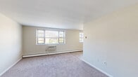 Located at 7801 Algon Ave in Philadelphia's 19111 zip code, this two-bedroom, one-bathroom unit offers a practical and functional single-floor layout. The living and dining area features light hardwood-style flooring, a ceiling fan, and large windows that allow natural light to fill the space, creating a bright and open atmosphere. Baseboard heating runs throughout, ensuring comfort year-round, complemented by wall-mounted HVAC units in the main rooms.

The generously sized primary bedroom is carpeted and features multiple windows with outdoor views, providing ample natural light. A second carpeted bedroom also includes a window, baseboard heating, and a closet with panel doors, offering practical storage. Both bedrooms maintain a clean, neutral palette with white trim and light-toned walls.

The full bathroom is finished with classic white subway tile wainscoting accented by a teal tile border, a mosaic tile floor in blue tones, and a white vanity cabinet topped with a mirrored medicine cabinet. The combination of retro tile detailing and clean white fixtures gives the bathroom a timeless character. Overall, this unit presents a straightforward, well-maintained layout suited for comfortable everyday living.