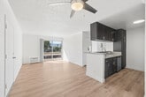 Located in Santa Clarita, CA, this thoughtfully designed 2-bedroom, 2-bathroom residence offers a comfortable and functional single-floor layout. Light wood-style flooring flows throughout the entire home, lending a clean, modern feel to every room.

The open-concept living and kitchen area forms the heart of the home. The kitchen features dark espresso cabinetry with ample upper and lower storage, a peninsula with a sink and counter seating, stainless steel appliances including a refrigerator, range, and microwave, and a recessed ceiling light. The living room extends naturally from the kitchen and is fitted with a ceiling fan and a sliding glass door that opens to a private balcony, offering sweeping views of the surrounding neighborhood, mature trees, and the Santa Clarita mountains beyond.

The spacious primary bedroom is filled with natural light through a large window with vertical blinds and includes a wall-length mirrored sliding closet. The second bedroom is equally bright and well-proportioned. Both bathrooms are finished with white cabinetry, grey countertops, and full tub-shower combinations, all complemented by the same warm wood-style flooring found throughout the home.

A textured ceiling and crown molding add subtle architectural character, while the light-toned walls and abundant natural light create an airy, welcoming ambiance throughout.