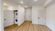 Located at 701 Downsby Ln in Woodstock, GA, this single-floor, 2-bedroom, 2-bathroom home offers a thoughtfully designed layout with contemporary finishes throughout. The kitchen is a standout feature, showcasing white shaker cabinetry with matte black hardware, warm wood lower cabinets, white quartz countertops, a tile backsplash, and a full suite of stainless steel appliances including a refrigerator with ice dispenser, electric range, and built-in microwave. A peninsula with an undermount sink provides additional prep space and casual seating potential. Light wood-tone luxury vinyl plank flooring runs through the main living areas, complementing the home's clean, neutral palette. Both bedrooms are carpeted and feature ceiling fans and windows that bring in natural light. The spacious primary bedroom connects to a well-equipped en-suite bathroom with a double-sink vanity, white quartz counters, warm wood cabinetry, a glass-enclosed walk-in shower with tile surround, and built-in shelving. The second bathroom offers a tub-shower combo with tiled surround and matching matte black fixtures. A dedicated laundry closet with a stacked washer and dryer adds everyday convenience, while dual closets in the primary bedroom provide ample storage.