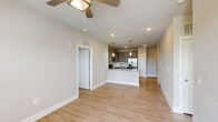 This single-floor, 2-bedroom, 2-bathroom residence in Lady Lake, Florida offers a thoughtfully designed layout with modern finishes throughout. The open-concept kitchen serves as the heart of the home, featuring granite countertops, gray shaker-style cabinetry, a subway tile backsplash, stainless steel appliances, and a peninsula with pendant lighting — all flowing seamlessly into the living area over light wood-look flooring. Natural light pours in through multiple windows, enhancing the bright, airy atmosphere.

Both bedrooms are carpeted for comfort, each equipped with a ceiling fan and windows with blinds that invite natural light. The primary bedroom is generously proportioned and connects to a private en-suite bathroom boasting a dual-sink vanity with granite countertops, gray cabinetry, and a tiled shower. The second full bathroom mirrors the same refined aesthetic, offering a granite-topped single vanity and a tiled tub-shower combination. Additional conveniences include two closets, a hallway, and a welcoming entrance. The neutral color palette and clean architectural lines throughout create a cohesive, modern living environment.
