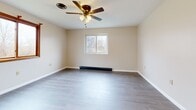 This 470 square foot apartment, located at 355 S Main St in Albion, NY, offers a thoughtfully designed living space on a single floor. The interior has been recently updated with modern finishes, creating a fresh and inviting atmosphere. The open-concept layout maximizes the use of space, seamlessly connecting the living room and kitchen areas.

The 140 square foot primary bedroom provides a comfortable retreat, featuring a large window that allows natural light to flood the space. The bathroom boasts a clean, contemporary design with a white tiled shower/tub combination and light wood-look flooring.

Throughout the apartment, neutral-toned walls and grey wood-look flooring create a cohesive, contemporary aesthetic. Large windows in both the living area and bedroom offer views of the surrounding greenery and fill the space with natural light. The living room is equipped with a ceiling fan for added comfort.

Storage solutions are integrated into the design, with a spacious closet featuring paneled sliding doors. The kitchen, while not fully visible in the images, appears to include modern appliances and cabinetry. Overall, this apartment combines efficiency and style, making excellent use of its compact footprint.