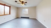 This 470 square foot apartment, located at 355 S Main St in Albion, NY, offers a thoughtfully designed living space on a single floor. The interior has been recently updated with modern finishes, creating a fresh and inviting atmosphere. The open-concept layout maximizes the use of space, seamlessly connecting the living room and kitchen areas.

The 140 square foot primary bedroom provides a comfortable retreat, featuring a large window that allows natural light to flood the space. The bathroom boasts a clean, contemporary design with a white tiled shower/tub combination and light wood-look flooring.

Throughout the apartment, neutral-toned walls and grey wood-look flooring create a cohesive, contemporary aesthetic. Large windows in both the living area and bedroom offer views of the surrounding greenery and fill the space with natural light. The living room is equipped with a ceiling fan for added comfort.

Storage solutions are integrated into the design, with a spacious closet featuring paneled sliding doors. The kitchen, while not fully visible in the images, appears to include modern appliances and cabinetry. Overall, this apartment combines efficiency and style, making excellent use of its compact footprint.