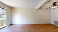 Located at 1505 N West St in Wichita, Kansas, this single-floor, one-bedroom unit offers a practical and comfortable layout. The combined kitchen and living room serves as the heart of the space, highlighted by warm wood-look flooring, neutral walls, and a textured ceiling throughout. A standout feature of the living area is the wood-framed fireplace, which anchors the room alongside a sliding glass door that opens to an outdoor view, bringing in natural light and a welcoming sense of openness. The galley-style kitchen is efficiently arranged with rich wood cabinetry lining both walls, white appliances including a range and refrigerator, light countertops, and a sink with ample storage above and below. The bedroom is generously sized, finished with plush carpet for comfort, and notably features two separate closets, providing substantial storage capacity. The clean, bright walls and textured ceiling carry a consistent aesthetic throughout the room. A dedicated utility room rounds out the floor plan, adding functional space for household needs. Overall, the unit presents a straightforward, well-organized layout with consistent finishes and practical amenities suited for comfortable everyday living in a convenient Wichita location.