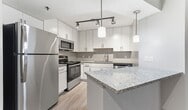 This 610 square foot apartment in Atlanta offers a thoughtfully designed one-bedroom layout. The space features an open-concept living area that seamlessly integrates the kitchen, dining, and living spaces. The kitchen is a highlight, boasting white cabinetry, granite countertops, and stainless steel appliances, including a refrigerator, stove, and built-in microwave. 

The living area is bright and spacious, with large windows and sliding glass doors that lead to a private balcony, allowing natural light to flood the space. The bedroom, measuring 170 square feet, provides ample room and includes a closet for storage. The bathroom features a modern design with a combination tub and shower, complemented by a granite-topped vanity.

Throughout the apartment, you'll find neutral-toned walls and wood-look vinyl flooring, creating a contemporary aesthetic. The unit also includes in-unit laundry facilities, adding convenience to daily life. With its efficient use of space and modern finishes, this apartment offers comfortable city living in a prime Atlanta location.