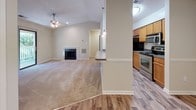 Located at 12520 Gayton Rd in Henrico, VA, this single-floor unit offers a well-designed layout that balances open communal spaces with comfortable private areas. The living area serves as the heart of the home, featuring vaulted ceilings, a ceiling fan, and a tile-surround fireplace that adds a classic focal point to the room. Neutral carpet throughout the living and bedroom areas creates a warm, cohesive atmosphere, while wood-look plank flooring runs through the kitchen, bathroom, and transitional spaces.

The kitchen is positioned adjacent to the living area and is equipped with stainless steel appliances, including a range, over-the-range microwave, and refrigerator. Warm-toned wood cabinetry provides ample storage, and a peninsula counter with pendant lighting connects the kitchen to the main living space.

The bedrooms are generously sized and carpeted, with neutral wall tones and good natural light. One bedroom features a sliding glass door that opens directly onto a private deck, offering pleasant outdoor views and access. Additional bedrooms include windows with exterior views and textured ceilings.

The bathroom features a full tub-shower combo with white tile surround, wood-look flooring, and a wood-cabinet vanity with a light countertop, completing this functional and well-maintained space.
