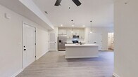 Located at 15 Millswood Dr in Clarksville, TN, this well-appointed single-story home offers a thoughtfully designed open-concept layout. The combined kitchen and living area serves as the heart of the home, featuring light wood-look luxury vinyl plank flooring, recessed lighting, and a ceiling fan that enhances airflow and comfort. The kitchen is a standout, outfitted with crisp white shaker-style cabinetry accented by matte black hardware, a classic white subway tile backsplash, gleaming white quartz countertops, and a full suite of stainless steel appliances including a French door refrigerator, range, and built-in microwave. A generously sized center island with an integrated sink and pendant lighting provides both additional prep space and a natural gathering spot. The living area opens toward French doors, allowing natural light to flow through. The spacious primary bedroom features plush carpeting, a ceiling fan, and a natural light-filled window. A dedicated closet offers ample storage. Both bathrooms are clean and functional, with one featuring a tiled tub/shower combination. Neutral tones and modern finishes throughout lend the home a fresh, cohesive aesthetic.