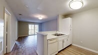 Located at 4793 N Pine Hills Rd in Pine Hills, Florida, this 2-bedroom, 2-bathroom unit offers a practical and well-appointed single-floor layout. The open-concept kitchen and living area forms the heart of the unit, where white cabinetry, a double-basin sink, a dishwasher, a gas range, and a full-size refrigerator line the galley-style kitchen. A peninsula counter separates the kitchen from the living area, which is finished with wood-style flooring and neutral-toned walls. A sliding glass door leads to a private balcony with views of surrounding trees, filling the living space with natural light. The primary bedroom is a comfortable size and features a ceiling fan, a window with blinds, and the same wood-style flooring found throughout. The second bedroom is similarly finished with light wood-style floors and neutral walls. Both bathrooms are clean and functional, each featuring a white vanity with under-cabinet storage, a large mirror, and light fixtures. One bathroom includes a full tub-shower combination with white tile surround. Throughout the unit, textured ceilings and clean white trim add a classic finishing touch to the overall design.