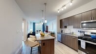 Located in San Jose, CA, this single-floor, 2-bedroom, 3-bathroom residence offers a thoughtfully designed open-concept layout. The kitchen is a standout feature, showcasing rich dark wood cabinetry, stainless steel appliances, a subway tile backsplash, and a central island with bar seating — all illuminated by elegant pendant lighting and track lights. It flows seamlessly into the bright living room, which is filled with natural light from large windows and features a ceiling fan and access to a private balcony. The primary bedroom includes plush carpeting, a well-organized walk-in closet with wire shelving, and an en-suite bathroom with a dual-sink vanity, dark wood cabinetry, white quartz countertops, and marble-style tile flooring. An in-unit stacked washer and dryer add everyday convenience. The second bedroom offers comfortable carpeting, a large window, and a charming striped accent wall. Bathrooms throughout include tub-shower combinations with marble-style tile surrounds. Light wood-look flooring runs through the main living areas, lending warmth and continuity to the overall design. Two closets and two hallways round out the functional, well-organized floor plan.