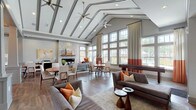 Located at 1875 S River Road in Saint Charles, Missouri, this single-story clubhouse is designed to serve as a sophisticated community gathering space. The entrance foyer sets an immediate tone of refinement, featuring herringbone-patterned flooring, structured columns with white wainscoting, and a statement sputnik chandelier suspended beneath a coffered ceiling detail.

The main gathering area is anchored by dramatic vaulted ceilings with exposed beams and multiple ceiling fans, creating an airy, expansive atmosphere. A wall of large, multi-pane windows floods the space with natural light and offers views of the surrounding outdoor area, including a pool. A floor-to-ceiling stacked stone fireplace with a sleek linear insert serves as a prominent focal point, complemented by curated seating arrangements in warm gray and rust tones.

The open layout accommodates multiple lounge and dining zones, seamlessly connected by wood-look flooring throughout. A private dining nook features built-in banquette seating with textured upholstery, decorative glass panels, and pendant lighting. The kitchenette is well-appointed with gray shaker cabinetry, stainless steel appliances, a mosaic tile backsplash, and white quartz countertops—ideal for hosting events.