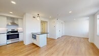 Located at 301 S 19th St in Philadelphia's desirable Rittenhouse Square neighborhood, this thoughtfully designed studio offers a clean, modern aesthetic throughout. The open-concept kitchen and living area is anchored by light-toned hardwood flooring, crisp white walls, and recessed lighting that creates a bright, airy atmosphere. The fully equipped kitchen is a standout feature, showcasing sleek flat-front white cabinetry, dark countertops, a white subway tile backsplash, and a full suite of stainless steel appliances including a refrigerator with ice maker, electric range with a stainless hood vent, dishwasher, and built-in microwave. A central island provides additional prep and storage space. The living area benefits from multiple double-hung windows that frame impressive panoramic views of the Philadelphia skyline, flooding the space with natural light. A dedicated hallway connects to the well-appointed bathroom, which features large-format neutral floor tiles, a glass-enclosed walk-in shower finished with elegant marble-style wall tile, and clean white fixtures. Ample closet space is accessible from the hallway. The overall design balances contemporary finishes with functional efficiency, making this a polished urban retreat in the heart of Philadelphia.