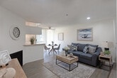 Located in the Westwood neighborhood of Los Angeles, this single-floor unit at 424 Kelton Ave offers a thoughtfully designed layout with a seamless flow between living, dining, and sleeping spaces. The open-concept living and dining area is anchored by warm wood-style flooring, a textured ceiling, and a ceiling fan that enhances air circulation. A cozy fireplace adds character to the living space, while vertical blinds frame access to a private balcony, allowing natural light to fill the room. A pass-through counter connects the living area to the galley kitchen, which features white cabinetry, granite-style countertops, a double stainless steel sink, and white appliances including a range and refrigerator — all set against clean, bright walls. The generously sized bedroom accommodates multiple beds and opens into a connecting hallway with ample closet space, lending a sense of flexibility and openness. The bathroom is neatly finished with white cabinetry, granite-style countertops, a large mirror, and hardwood-style flooring, with a separate water closet providing added privacy. Throughout the unit, consistent wood-style flooring, recessed lighting, and a neutral color palette create a cohesive and inviting atmosphere ideal for comfortable urban living.