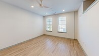 Located at 577 Meeting St in Charleston's vibrant 29403 zip code, this single-floor unit offers a thoughtfully designed layout that maximizes function and style. Light-toned hardwood flooring runs throughout, complementing the clean white walls and creating a bright, cohesive aesthetic.

The open-concept kitchen and living area serves as the heart of the unit. The kitchen is outfitted with warm wood-grain cabinetry, light granite countertops, stainless steel appliances including a range, microwave, and refrigerator, and a central island with a sink and pendant lighting overhead — providing both prep space and a natural gathering point. Recessed lighting and a ceiling fan keep the living area comfortable and well-lit, while multiple windows dressed with horizontal blinds invite natural light and views of the surrounding neighborhood.

The bathroom features a full tub-shower combination with marble-look tile surround, wood-toned flooring, a granite-topped vanity, and chrome fixtures, offering a clean and polished finish. The dedicated closet is equipped with wire shelving systems that provide organized, multi-level storage.

Throughout the unit, thoughtful details — from crown molding accents to recessed lighting — reflect a modern yet comfortable design sensibility well-suited to Charleston's dynamic urban setting.