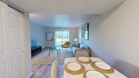This single-floor, 4-bedroom, 1-bathroom unit offers a practical and well-designed layout making efficient use of its compact footprint. The open-concept living and dining area is anchored by light-toned luxury vinyl plank flooring and neutral walls, creating a bright and airy atmosphere. A large sliding glass door in the living room floods the space with natural light while providing views of the outdoor greenery beyond. The dining area sits adjacent to the living room, offering a defined space for meals with easy flow between rooms. The galley-style kitchen is a standout feature, showcasing white shaker cabinetry with matte black hardware, marble-look countertops, a classic subway tile backsplash, and stainless steel appliances, all contributing to a clean, modern aesthetic. A dedicated hallway connects the four bedrooms, each offering comfortable accommodation, with the primary bedroom providing a generous personal retreat. The shared full bathroom features a white vanity with a matte black faucet and a mirrored medicine cabinet. A dedicated laundry area with a washer and dryer adds everyday convenience. Throughout the unit, consistent flooring, neutral tones, and thoughtful finishes create a cohesive and move-in-ready environment.
