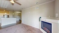 Located at 4910 N Monroe St in Tallahassee, FL, this well-appointed 2-bedroom, 2-bathroom residence offers a thoughtfully designed single-floor layout with a generous overall footprint. The open-concept kitchen and dining area serves as the heart of the home, showcasing crisp white cabinetry, granite countertops, stainless steel appliances, a central island with pendant lighting, and durable wood-look flooring. The living room is warm and inviting, highlighted by a corner fireplace with a classic white mantel, soft carpet, crown molding, and a ceiling fan. Natural light filters in through large windows with blinds, adding brightness throughout.

Both bedrooms are carpeted and feature ceiling fans and ample natural light. The primary bedroom includes a spacious walk-in closet with wire shelving, while additional closets throughout the unit provide exceptional storage — five in total. The two bathrooms mirror the kitchen's refined aesthetic with granite-topped vanities and white cabinetry. A dedicated laundry room with wire shelving and washer/dryer hookups adds everyday convenience. The unit also includes a private patio, accessible from the main living area, perfect for outdoor relaxation.