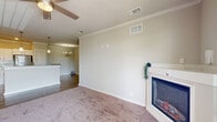 Located at 4910 N Monroe St in Tallahassee, FL, this well-appointed 2-bedroom, 2-bathroom residence offers a thoughtfully designed single-floor layout with a generous overall footprint. The open-concept kitchen and dining area serves as the heart of the home, showcasing crisp white cabinetry, granite countertops, stainless steel appliances, a central island with pendant lighting, and durable wood-look flooring. The living room is warm and inviting, highlighted by a corner fireplace with a classic white mantel, soft carpet, crown molding, and a ceiling fan. Natural light filters in through large windows with blinds, adding brightness throughout.

Both bedrooms are carpeted and feature ceiling fans and ample natural light. The primary bedroom includes a spacious walk-in closet with wire shelving, while additional closets throughout the unit provide exceptional storage — five in total. The two bathrooms mirror the kitchen's refined aesthetic with granite-topped vanities and white cabinetry. A dedicated laundry room with wire shelving and washer/dryer hookups adds everyday convenience. The unit also includes a private patio, accessible from the main living area, perfect for outdoor relaxation.