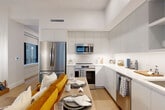 Located in the heart of Washington, DC, this well-appointed one-bedroom, one-bathroom unit at 1425 New York Ave NW offers a thoughtfully designed layout across a single floor. The open-concept living, dining, and kitchen area serves as the heart of the home, featuring light wood flooring, high ceilings, and a bright, airy atmosphere. The modern kitchen is outfitted with sleek gray flat-panel cabinetry extending to the ceiling, stainless steel appliances including a French door refrigerator, range, microwave, and dishwasher, complemented by white quartz countertops and a marble-inspired tile backsplash. A dedicated office nook provides a built-in desk workspace bathed in natural light from large windows overlooking the urban streetscape. The bedroom is a calm retreat with a closet, warm wood flooring, and soft neutral tones. The bathroom features elegant marble-look tile flooring, a white vanity with ample storage, a large mirror, and a full tub-shower combination with white tile surround. A private balcony offers an outdoor escape with city views. Additional conveniences include in-unit laundry and two closets, rounding out this efficient and stylish urban residence.
