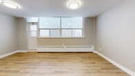Located at 25 Leith Hill Road in Toronto's Don Mills neighbourhood, this well-appointed 2-bedroom, 1-bathroom unit offers a practical and comfortable layout across a single floor. Light-toned laminate flooring flows throughout the living areas and bedrooms, creating a cohesive and clean aesthetic.

The combined kitchen and living area forms the heart of the unit. The kitchen has been updated with crisp white cabinetry, white quartz-style countertops, a subway tile backsplash, and a full suite of stainless steel appliances including a refrigerator, electric range, and dishwasher. A breakfast bar peninsula provides additional counter space and casual dining options. The adjacent living area benefits from large windows that bring in generous natural light and offer views of the surrounding cityscape.

The primary bedroom is a comfortable size, featuring two double sliding-door closets and a window with an urban outlook. The second bedroom also includes a mirrored sliding-door closet and its own window, allowing for ample natural light. Both bedrooms are equipped with baseboard heating.

The bathroom includes a soaking tub with a tile surround, a vanity with a wood-toned cabinet, and a small window for ventilation. A hallway connects the main spaces, completing this well-organized and move-in-ready unit.