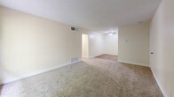 Located at 2545 Fulton Ave in Arden-Arcade, CA, this two-bedroom, one-bathroom unit offers a well-organized single-floor layout designed for comfortable everyday living. The combined kitchen and living area serves as the heart of the home, with the living space featuring neutral carpet, a textured ceiling, and a window that invites natural light and outdoor views of surrounding greenery. A ceiling fan adds comfort to the adjoining area. The galley-style kitchen is efficiently designed with white cabinetry, granite-look countertops, a double sink, and white appliances including a coil-top range and refrigerator, all set over warm wood-style flooring. The primary bedroom is generously sized, with soft carpet underfoot, a large window, and an expansive wall of bifold closet doors providing substantial storage. The second bedroom similarly features plush carpet, neutral walls, and dual bifold closets, making it equally functional. A hallway connects the main living areas to the full bathroom, which features a tiled shower-tub combination, a vanity with a granite-look countertop, and rich wood-style flooring. Clean, light-toned walls throughout the unit create a bright and cohesive aesthetic.