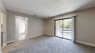Located in Dixon, CA, this single-floor, 2-bedroom, 2-bathroom residence offers a thoughtfully laid-out floor plan designed for comfortable everyday living. The living room is a welcoming, carpeted space bathed in natural light, anchored by a sliding glass door that opens to a private balcony with pleasant outdoor views of surrounding greenery. Neutral-toned walls and a textured ceiling carry throughout, creating a cohesive and clean aesthetic.

The galley-style kitchen is a functional highlight, featuring granite-look countertops, gray lower cabinetry, white upper cabinets, stainless steel appliances including a gas range and refrigerator, and light hardwood-style flooring. An adjacent dining area provides a seamless transition between cooking and dining spaces.

Both bedrooms are generously sized with plush carpeting and ceiling fans with light fixtures. The primary bedroom offers direct access to its en-suite bathroom, which is outfitted with a granite-topped vanity, gray cabinetry, and a full tub-shower combination. The second bathroom mirrors the same refined finishes. The unit also features abundant closet space across five closets, including a walk-in closet with built-in shelving and hanging rods. A connecting hallway ties all rooms together efficiently.