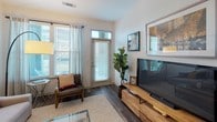 Located at 5620 Keltonwood Rd in Charlotte, NC, this single-floor residence offers a thoughtfully designed layout with contemporary finishes throughout. The living room is bright and welcoming, featuring wood-look plank flooring, a glass-paneled entry door with transom window, and window treatments that allow generous natural light. A warm natural wood media console anchors the space, complemented by curated wall art and a lush fiddle-leaf fig plant.

The kitchen is outfitted with crisp white shaker cabinetry, granite countertops, a subway tile backsplash, and a full suite of stainless steel appliances including a French door refrigerator, electric range, over-the-range microwave, and dishwasher. Wood-look flooring continues seamlessly through this area.

Both bedrooms offer plush carpeting, natural light through blinds and decorative curtains, and ample space for furnishings. The primary bedroom is generously sized with room for a king bed and additional storage. The en-suite bathroom features a granite-topped vanity with white cabinetry, wood-look tile flooring, and a full tub-shower combination. A second bathroom mirrors these quality finishes, providing convenience for guests or additional occupants. The overall ambiance is clean, modern, and move-in ready.