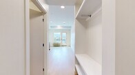 Located at 235 Hollywood Rd N in Kelowna, BC, this efficiently designed studio unit offers a bright and modern living experience on a single floor. The open-concept layout seamlessly integrates the kitchen and living area, making excellent use of the available space. The kitchen is well-appointed with warm wood-toned lower cabinetry, crisp white upper cabinets, a white tile backsplash, a stainless steel refrigerator, and a stove, all complemented by light-toned laminate flooring that runs throughout the unit.

The living area is filled with natural light, thanks to a large window and a glass-panelled balcony door that opens to a private outdoor space with sweeping mountain views — a standout feature of this unit. A wall-mounted HVAC unit ensures year-round comfort.

The entryway includes a built-in bench and open shelving for convenient storage, along with a closet, providing practical organization from the moment you step inside. The bathroom features a clean, all-white aesthetic with a glass-door stand-up shower and modern fixtures.

Recessed and flush-mount ceiling lighting throughout the unit enhances the bright, airy atmosphere. The overall design is contemporary and minimalist, with a neutral palette that creates a welcoming and functional living environment.