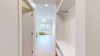 Located at 235 Hollywood Rd N in Kelowna, BC, this efficiently designed studio unit offers a bright and modern living experience on a single floor. The open-concept layout seamlessly integrates the kitchen and living area, making excellent use of the available space. The kitchen is well-appointed with warm wood-toned lower cabinetry, crisp white upper cabinets, a white tile backsplash, a stainless steel refrigerator, and a stove, all complemented by light-toned laminate flooring that runs throughout the unit.

The living area is filled with natural light, thanks to a large window and a glass-panelled balcony door that opens to a private outdoor space with sweeping mountain views — a standout feature of this unit. A wall-mounted HVAC unit ensures year-round comfort.

The entryway includes a built-in bench and open shelving for convenient storage, along with a closet, providing practical organization from the moment you step inside. The bathroom features a clean, all-white aesthetic with a glass-door stand-up shower and modern fixtures.

Recessed and flush-mount ceiling lighting throughout the unit enhances the bright, airy atmosphere. The overall design is contemporary and minimalist, with a neutral palette that creates a welcoming and functional living environment.