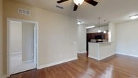 This single-story residence at The Park at Southwood offers a thoughtfully designed layout with a cohesive blend of comfort and functionality. The open-concept living and dining area is anchored by warm hardwood-style flooring that extends throughout the main living spaces, complemented by neutral wall tones and clean white baseboards that create a bright, welcoming atmosphere. Ceiling fans are present throughout, enhancing airflow and comfort. The kitchen features rich, dark wood cabinetry, granite-style countertops, a breakfast bar with pendant lighting overhead, and black appliances including a gas range, built-in microwave, and refrigerator. The bedrooms are carpeted and generously sized, each equipped with ceiling fans and multiple windows dressed with horizontal blinds that allow ample natural light to filter in. The bathrooms maintain design consistency with dark wood vanities, granite-style countertops, and hardwood-style flooring. One bathroom includes a full tub-shower combination with white tile surround. A secondary half bath provides added convenience. Throughout the home, the neutral palette and quality finishes create a clean, move-in-ready environment.