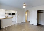 Located at 1001 Sherman Street in Denver, CO, this single-floor residence offers a clean, functional layout designed to maximize everyday livability. The open living area features light hardwood flooring that extends throughout, complemented by crisp white walls and a ceiling-mounted light fixture that keeps the space bright and welcoming.

The kitchen is thoughtfully designed with white cabinetry, a butcher block-style countertop, and a pass-through bar that connects it seamlessly to the main living area. Stainless steel appliances, including a refrigerator and built-in microwave, provide modern convenience, while an under-cabinet range hood adds a practical touch. A single-basin sink sits beneath the pass-through, making the kitchen both efficient and accessible.

One of the most distinctive architectural features of this space is the elegant arched doorway that leads from the living area into the hallway, lending a classic character to the otherwise contemporary interior. The entryway includes a solid front door with modern hardware, offering a secure and polished first impression.

The neutral color palette throughout the space creates a versatile backdrop suitable for a variety of interior styles. Situated in the Capitol Hill neighborhood of Denver, this residence combines timeless design details with a practical, single-level floor plan.