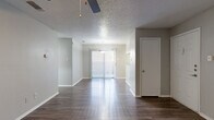 This single-story, 2-bedroom, 2-bathroom residence offers a functional and comfortable layout across a well-utilized footprint. The living room serves as the centerpiece of the home, showcasing a white brick fireplace flanked by built-in shelving, durable wood-look flooring, a ceiling fan, and a textured ceiling. A sliding glass door allows natural light to pour in, extending the feel of the space outward. The kitchen is efficiently designed with granite countertops, white cabinetry, stainless steel appliances including a refrigerator and electric range, and a built-in pantry closet offering generous storage. Both bedrooms feature plush wall-to-wall carpeting, ceiling fans, and access to closets — including a walk-in closet with built-in shelving. The primary bedroom is comfortably sized with a sliding door panel and its own ceiling fan. The bathrooms are clean and functional, each featuring a shower-tub combination with tiled surround and wood-look flooring. A connecting hallway ties the layout together seamlessly. Neutral gray walls and consistent finishes throughout create a cohesive, move-in ready atmosphere suited for a variety of lifestyles.