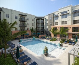 Sparkling Swimming Pool with Cabanas and Lounge Chairs - Evelyn City Lofts